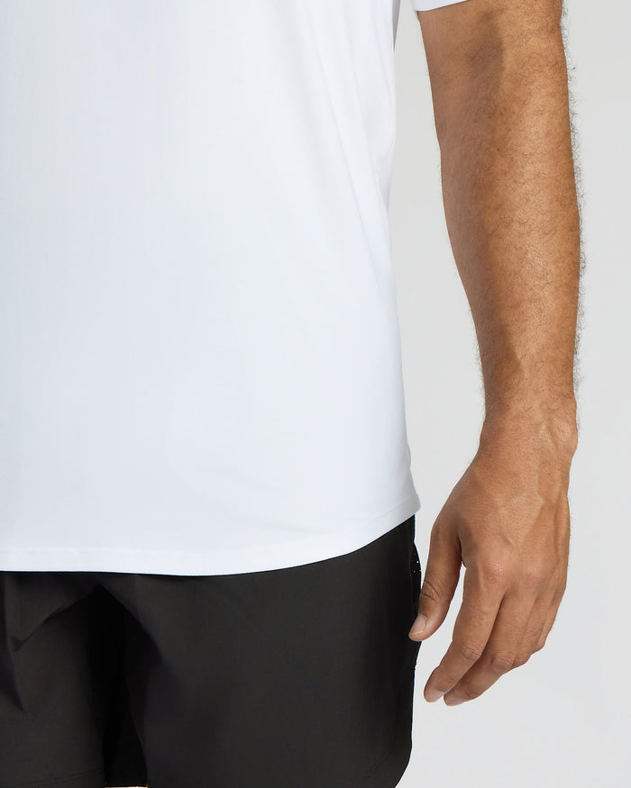 Person wearing a white shirt and black pants on a plain background