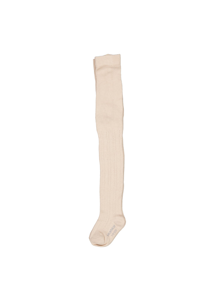 Lys beige strømpebukse med pointelle-look vist på ét ben