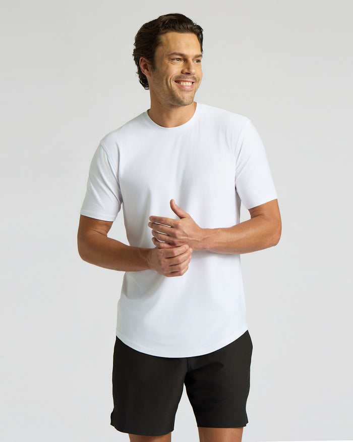 Man wearing a white t-shirt and black shorts on a light gray background