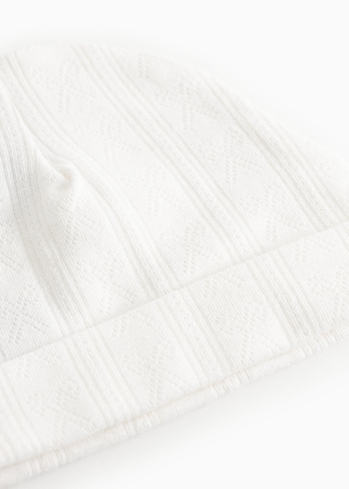 White baby hue in a light patterned knit with rib edge.