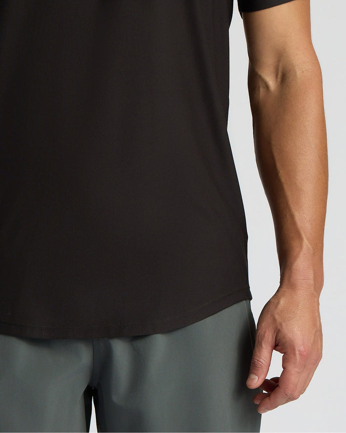 Person wearing a black sleeveless shirt and gray shorts on a light gray background