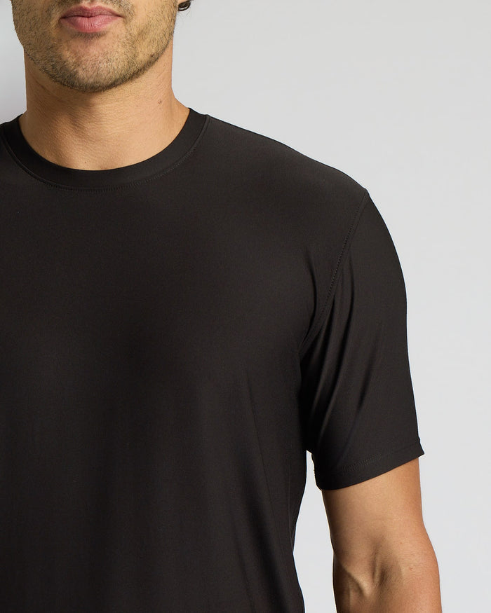 Black t-shirt worn by a person on a plain background
