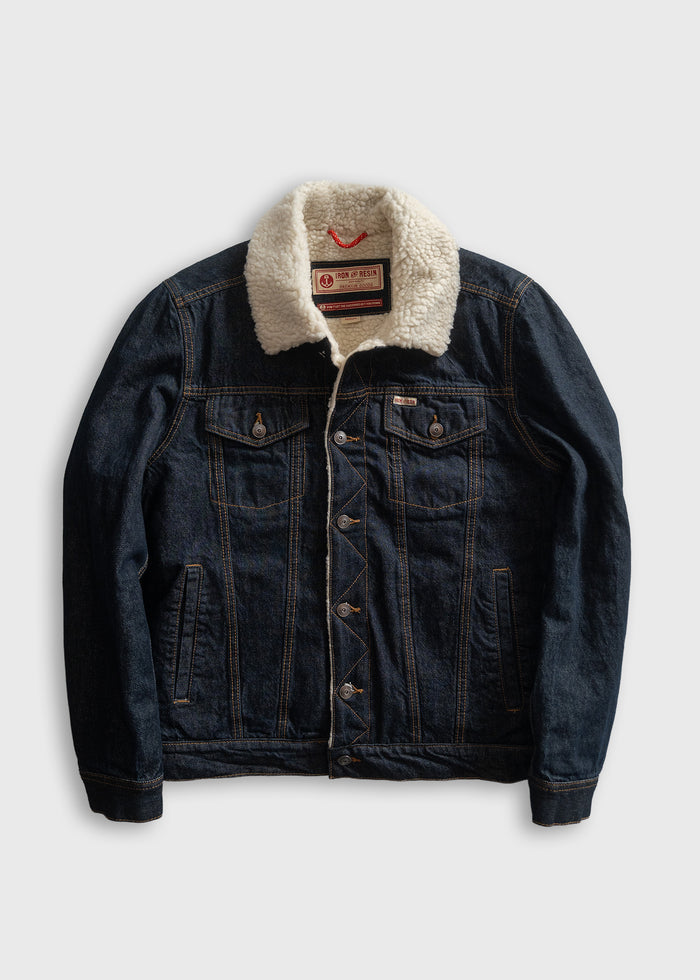 Denim jacket with a white sherpa collar, buttoned front, and two chest pockets, laid flat on a light gray background.