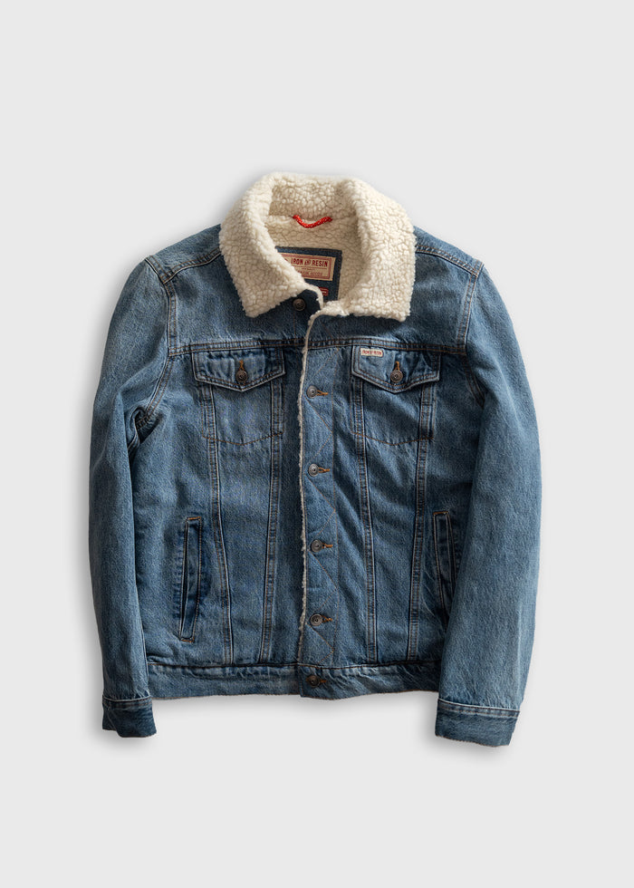 Denim jacket with sherpa collar, buttoned front, and chest pockets on a plain background. Casual and stylish outerwear.