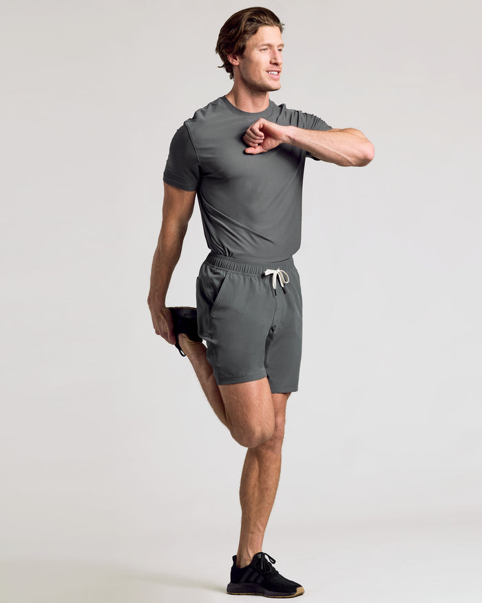 Man stretching in 9 All Carbon Active Quick Dry Shorts.