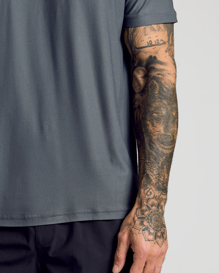 Carbon Active Crew Neck Tee on tattooed forearm and hand.