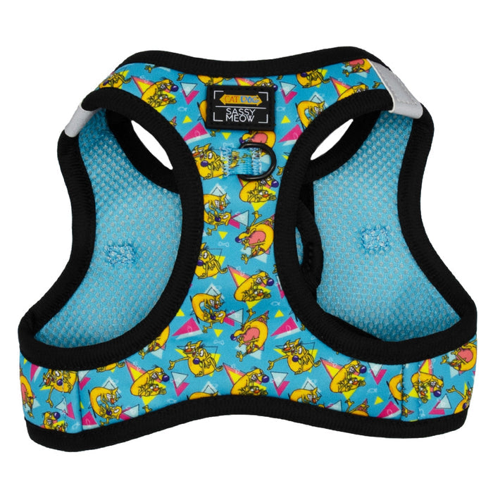 The Sassy Woof Cat Step-In Harness - Nickelodeon CatDog™ is a blue neoprene harness with black trim, featuring playful yellow cartoon cats and geometric shapes, a CAT DOG MEOW label, and D-ring for leash attachment.