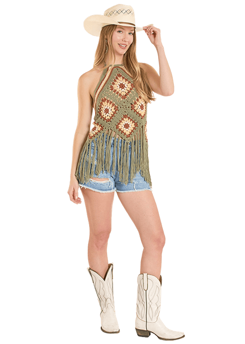 Woman in crochet top, denim shorts, and cowboy boots