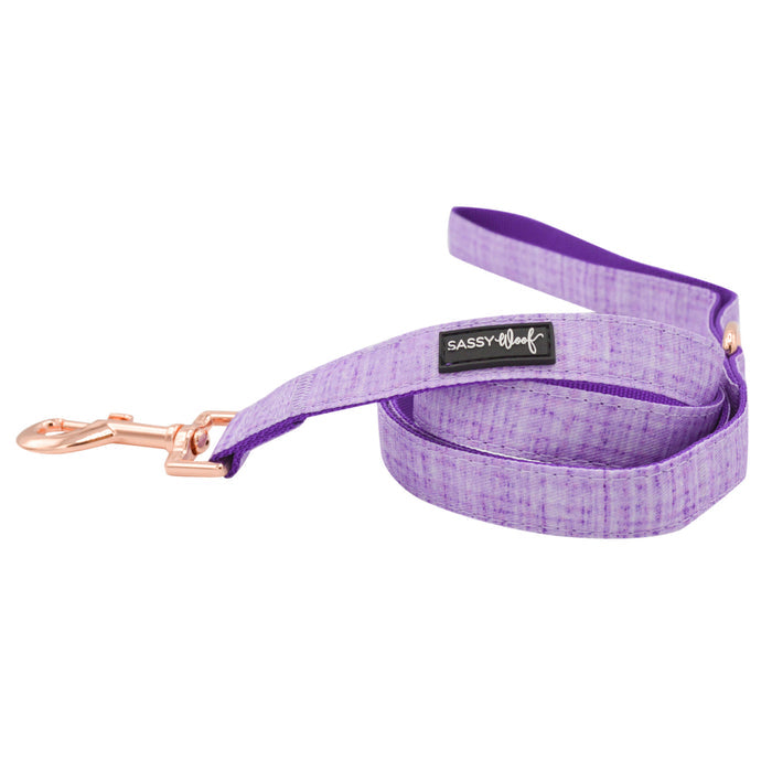 The Sassy Woof Dog Leash - Aurora is a vibrant purple leash with rose gold hardware and a black Sassy Woof label, shown loosely coiled on a white background—perfect to pair with matching harness and collar.