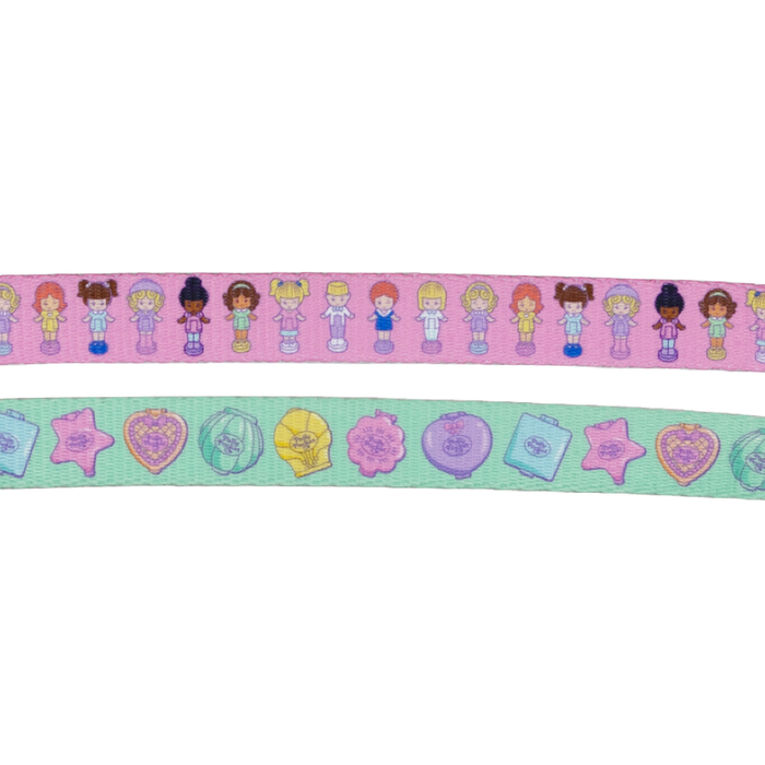 The Sassy Woof Dog Leash - Polly Pocket™ features a pink ribbon with diverse illustrated girls and a green one with playful icons like hearts, stars, and suitcases—adding charming pastel details to your pup’s walks.