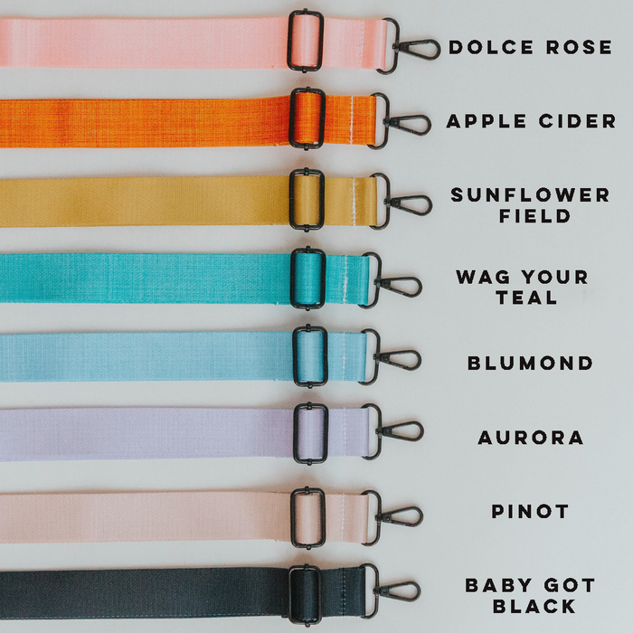 Eight vibrant, adjustable straps for the Sassy Woof Dog Parent Bag – Strap Only are lined up vertically and feature metal clasps. Each strap is labeled with playful names in pink, orange, yellow, teal, blue, mint green, lavender, and black.