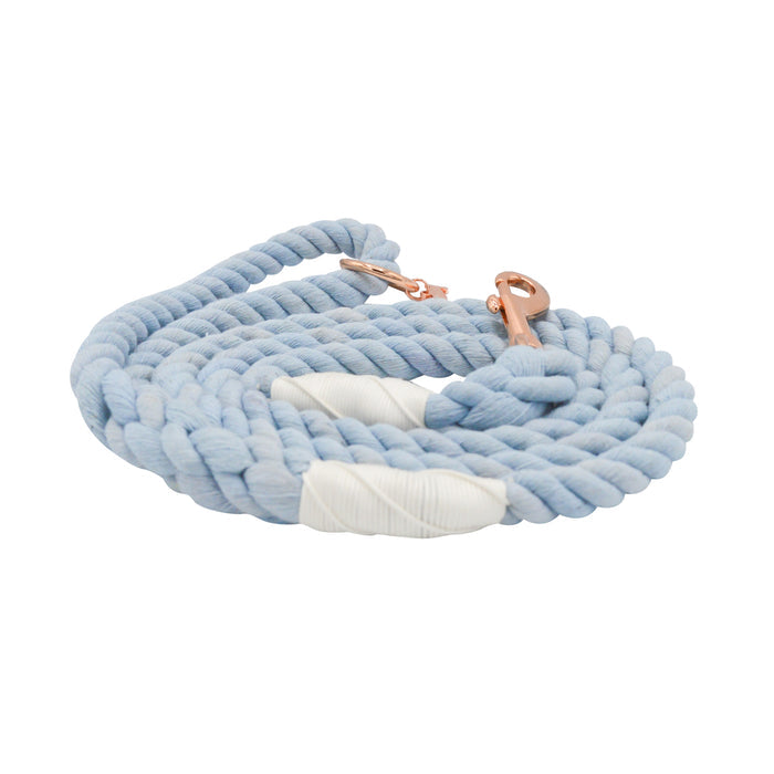 The Sassy Woof Dog Rope Leash - Azul is a coiled light blue cotton leash for dogs, featuring white wrapped accents near a copper-colored clasp, shown on a white background.