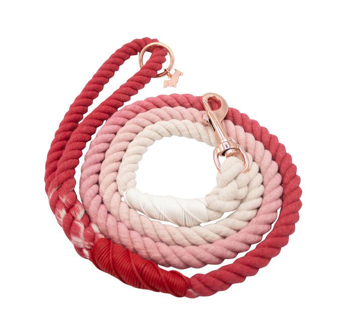 The Sassy Woof Dog Rope Leash - Poppy is hand-crafted from cotton with ombre shades from red to light pink. Gold hardware and a dog-shaped charm combine style and function in this unique accessory.
