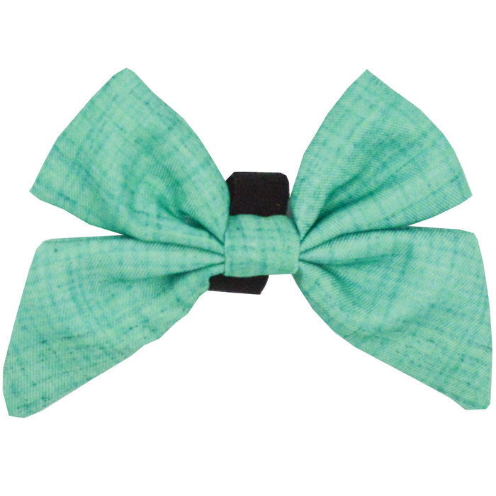 The Dog Sailor Bow - Wag Your Teal by Sassy Woof features teal fabric with two loops and tails, attached to a black elastic band—perfect for your pup's style.