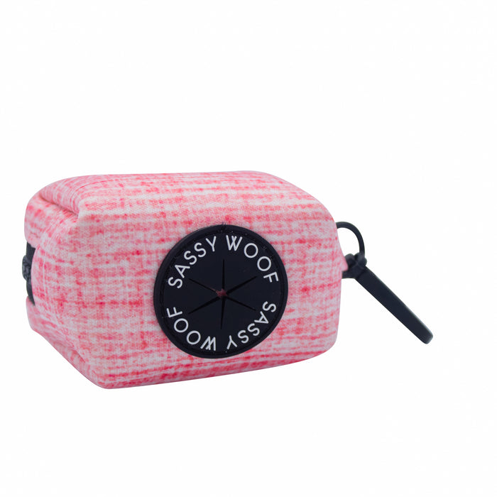 The Sassy Woof Dog Waste Bag Holder - Dolce Rose, in pink and white plaid, has a black dispenser and sturdy clip—perfect for adding style and convenience to your dog walks. Easily attach it to any leash or bag.