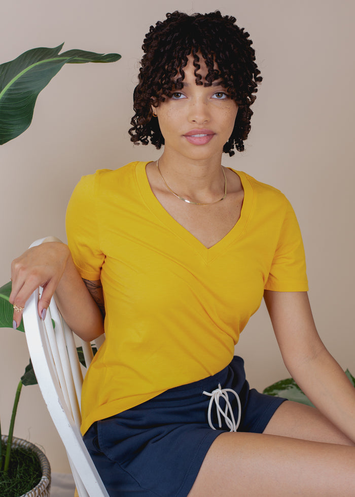 woman wearing gold vneck tee