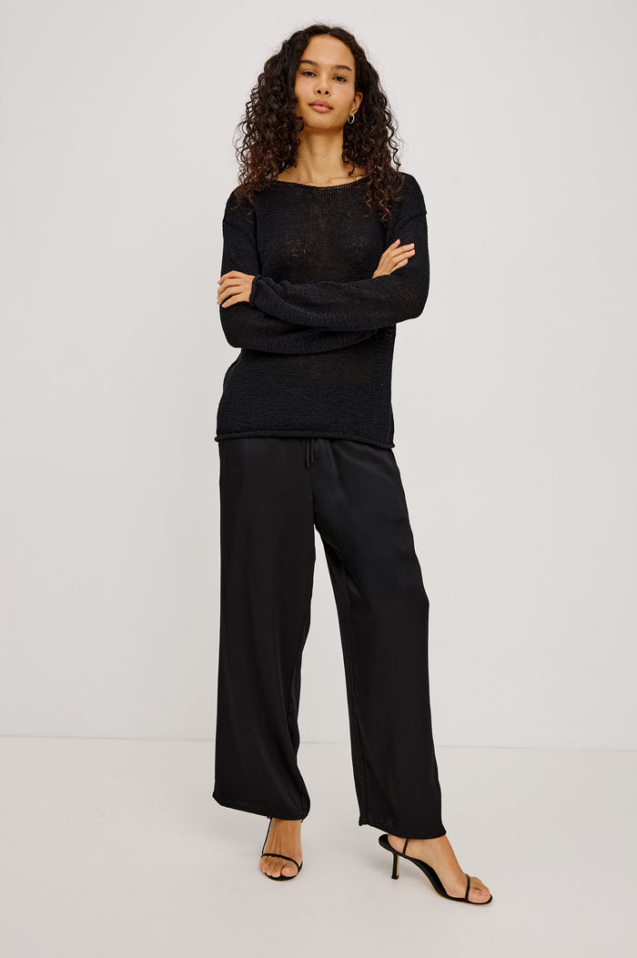 Evangeline Sweater in Luxe Linen Blend With Open Weave, Boat Neck, Relaxed Dropped Shoulders, and Long Sleeves in Black Colorway - Full Body Front View Featured on Model