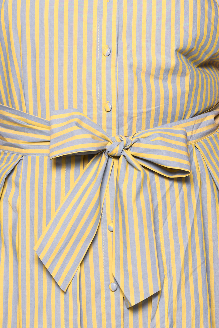 A close-up of the Glen Dress in Green Stripe by Ivy City Co, featuring nursing-friendly details, a button-down front, and a large striped bow tied at the waist.