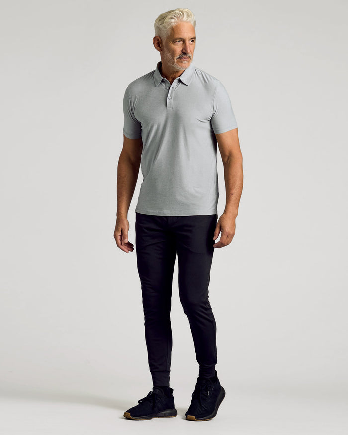 Man wearing Heather Light Gray Active Polo with black pants and shoes.
