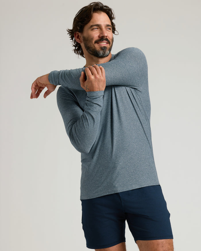 Man in Heather Navy Active Long Sleeve Crew T-Shirt doing a stretch.