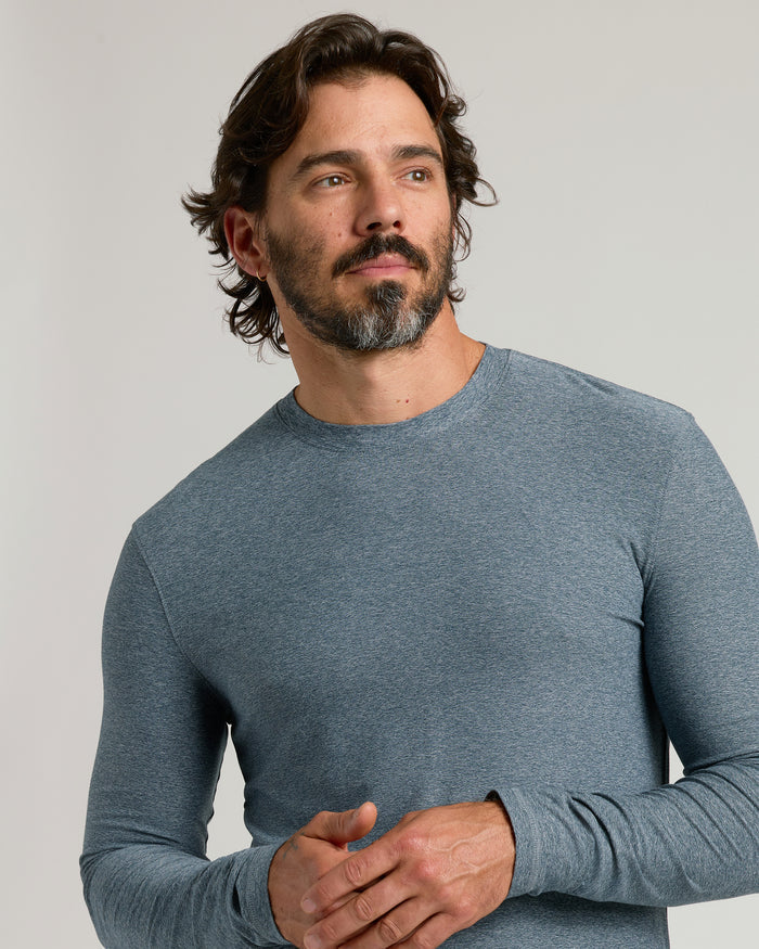 Man wearing Heather Navy Active Long Sleeve Crew T-Shirt, looking sideways.