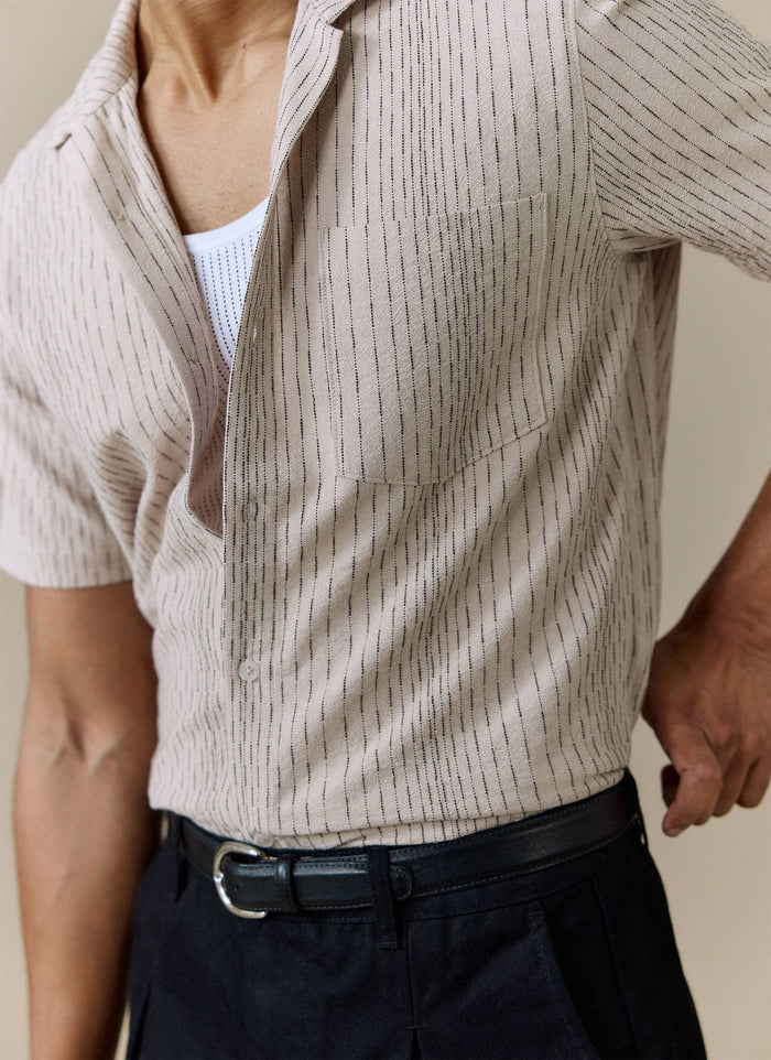 Close-up of the Percival Leland Cuban Shirt in cream cotton with fine black vertical stripes and a chest pocket.