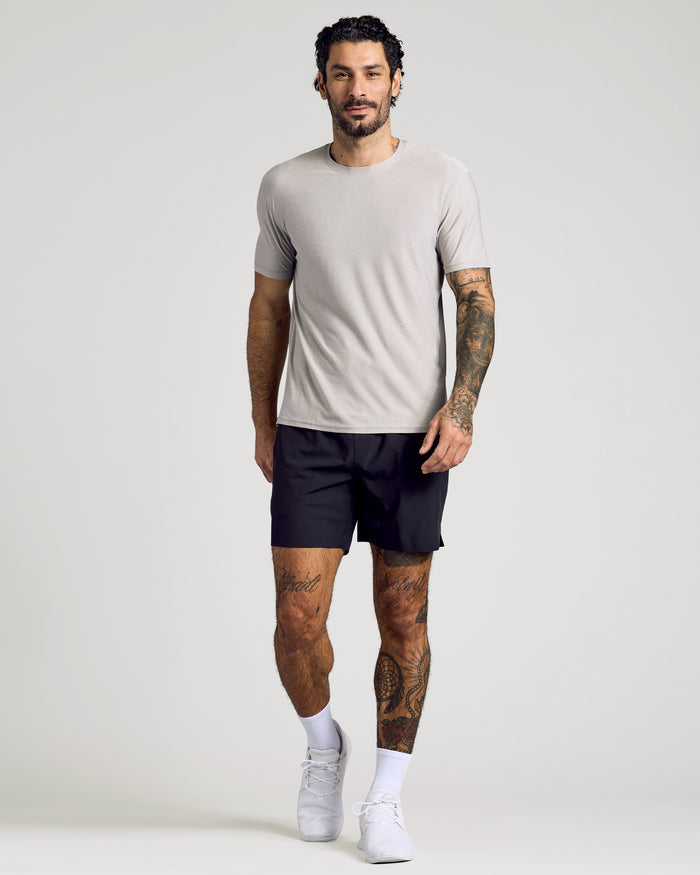 Man wearing Light Heather Gray Active Crew Neck Tee, black shorts, white shoes.