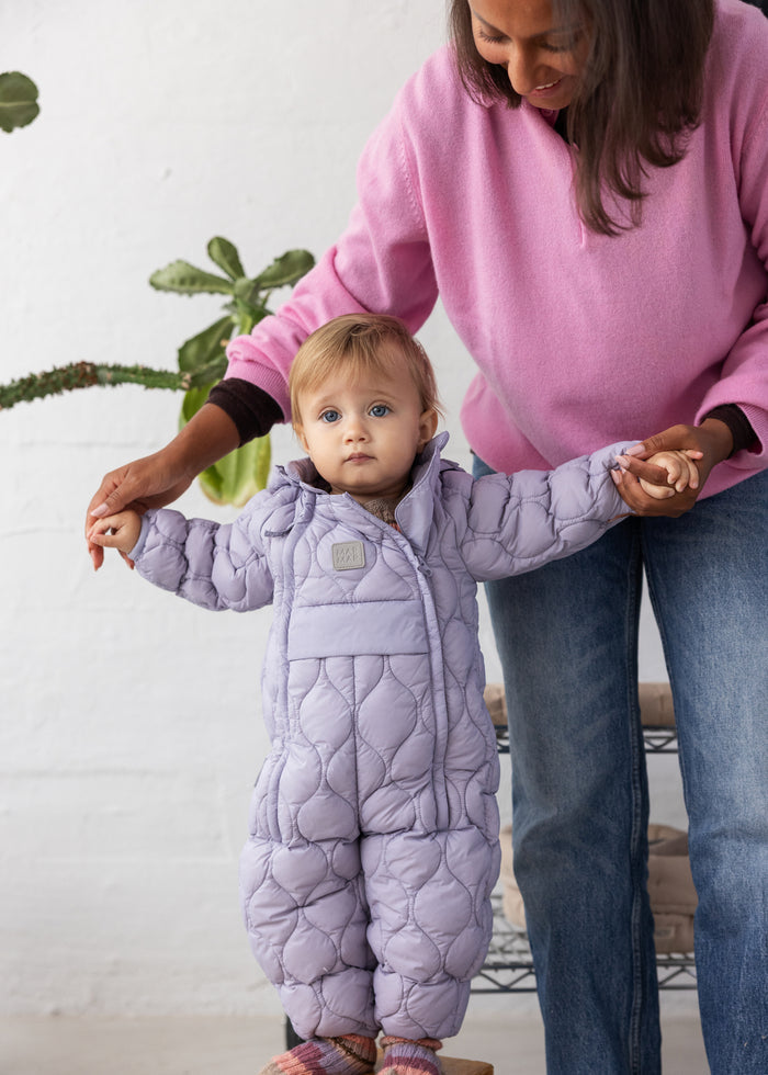 Lavender hoodie with hood and quilted pattern; button/label at the chest.