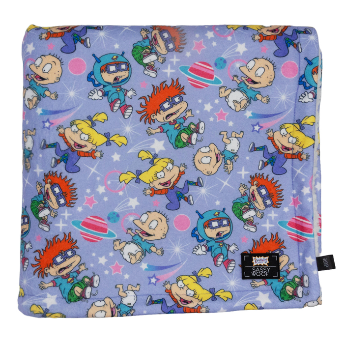 The Sassy Woof Pet Blanket - Nickelodeon Rugrats™ is a soft sherpa dog blanket with a light purple background featuring Tommy, Chuckie, Angelica, and Phil among planets and stars—perfect for your furry friend!.