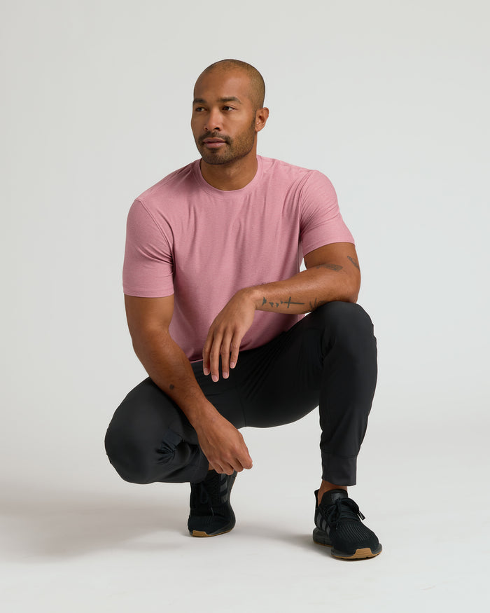 Man wearing Quartz Rose Active Crew Neck Tee, crouched in studio.