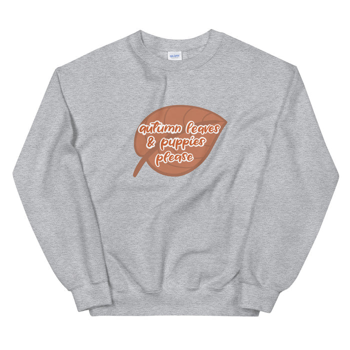 The Sassy Woof Sweatshirt - Autumn Leaves & Puppies Please is a cozy gray crewneck featuring a brown leaf graphic and "autumn leaves & puppies please" in white and orange—perfect for fall activities with your pup.