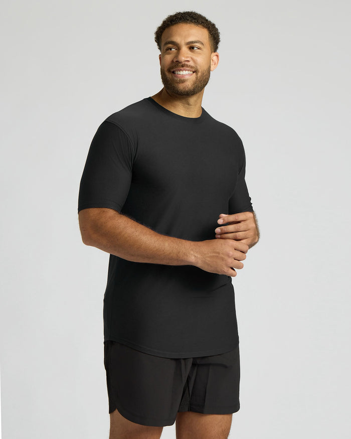 Man wearing a black t-shirt and shorts on a gray background