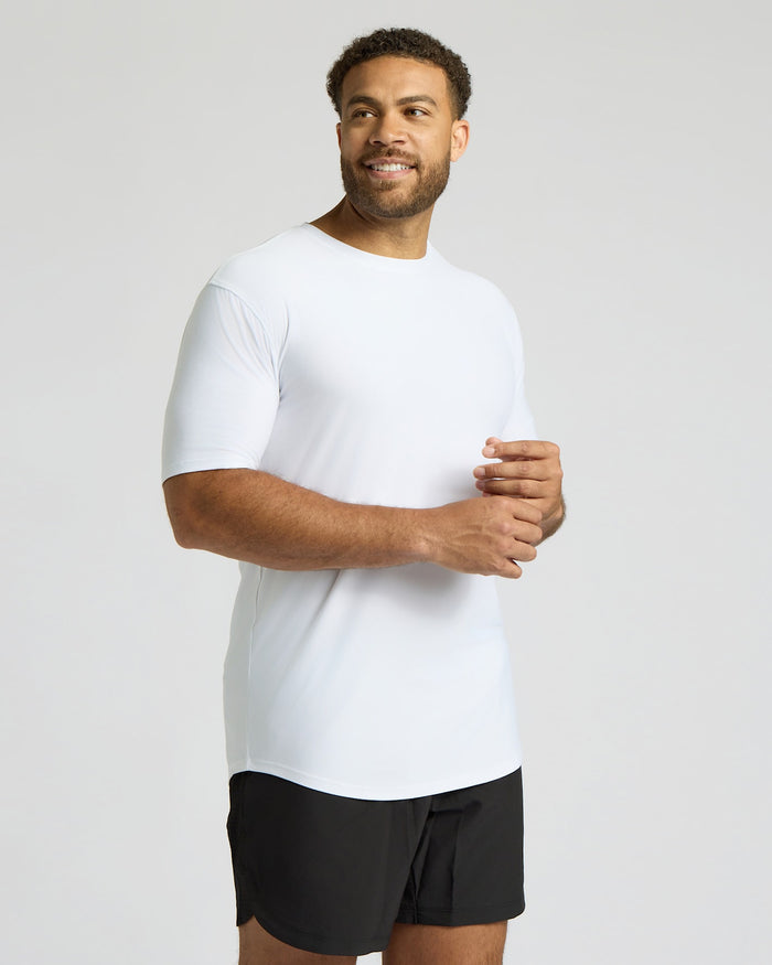 Man wearing a white t-shirt and black shorts on a plain background