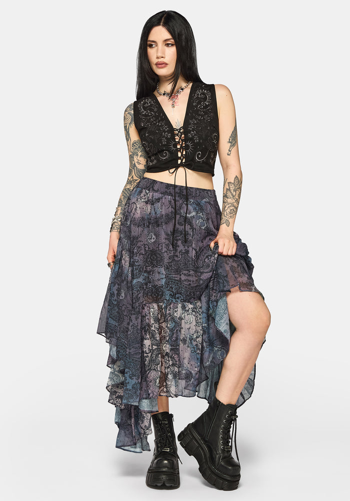 Woman wearing a black lace-up top with intricate designs on a plain background