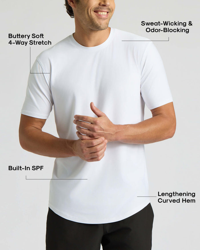 Man wearing a white crew neck t-shirt with a lengthening curved hem, featuring buttery soft 4-way stretch fabric, sweat-wicking and odor-blocking properties, and built-in SPF in the All White Active Curved Hem Crew 6-Pack.