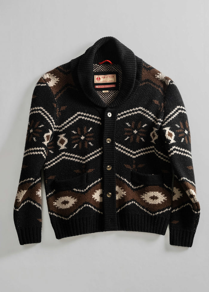 Black shawl collar cardigan with brown and white geometric patterns, buttoned front, and two pockets on a plain background.
